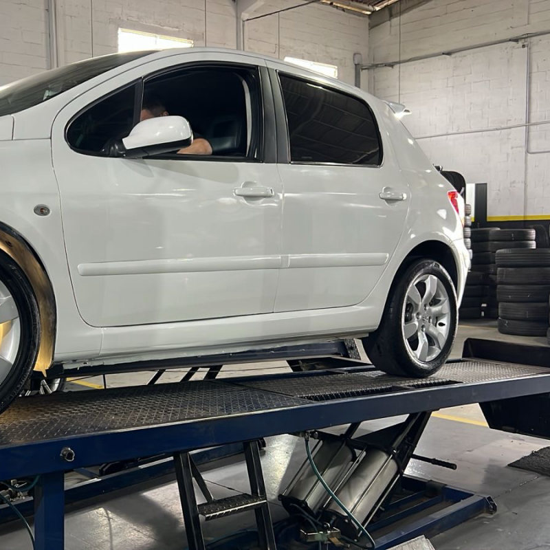 Carro branco em cima da rampa de alinhamento da Ferreira Auto Center